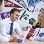 students going through study books with an advisor