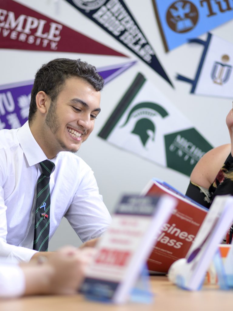 students going through study books with an advisor