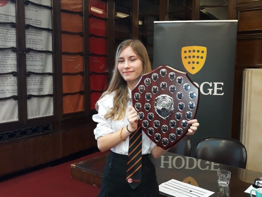a girl holding a shield of awards