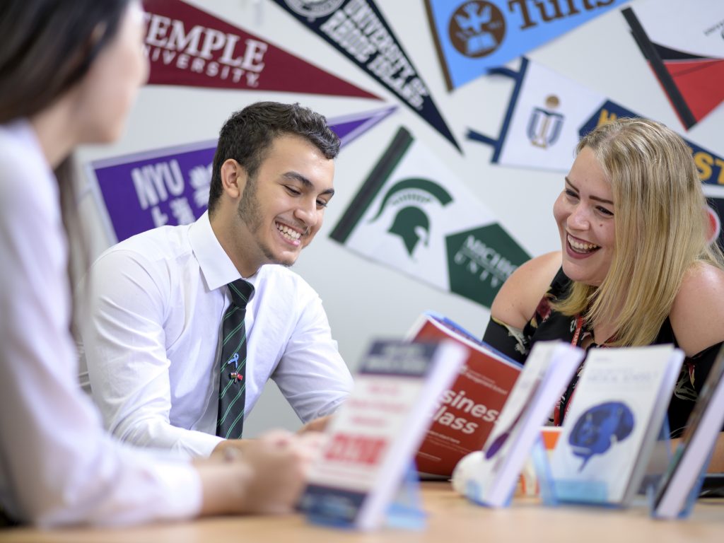 students from a sixth form college in Cardiff talking to their teacher and smiling