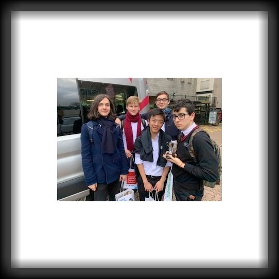 Children from a private school in Cardiff standing in front of a mini bus