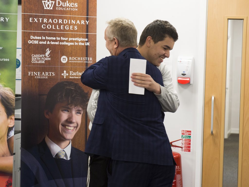 a teacher congratulating a student at a top sixth form college