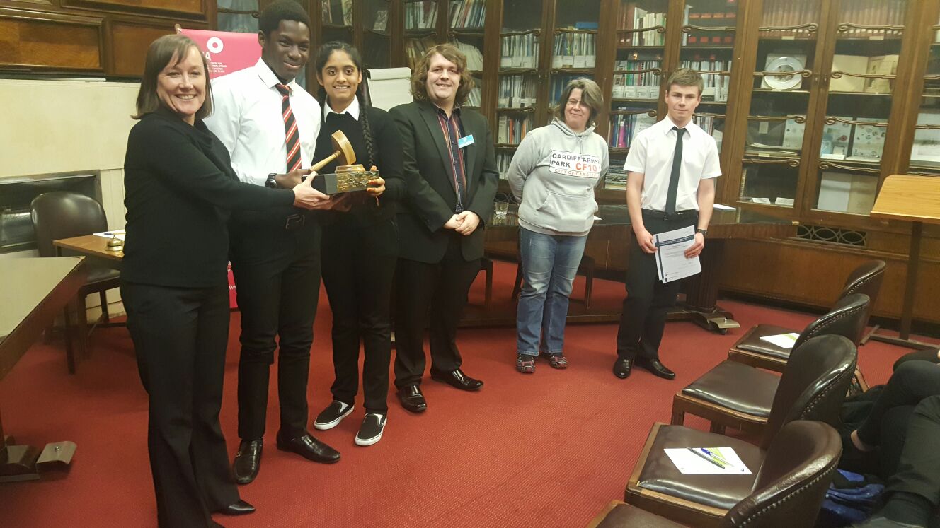 Cardiff Sixth Form College students receive a trophy from Jo Stevens MP, after winning the Wales Schools Debating Championships Grand Finals