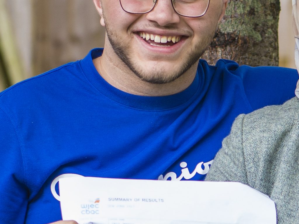 A top student from a private school in Cardiff smiling with his exam results