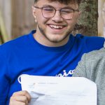 A top student from a private school in Cardiff smiling with his exam results