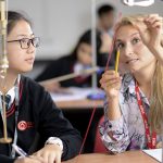 A science teacher helping a student at a sixth form college in Cardiff