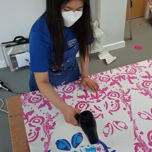 student using a hairdryer on a canvas