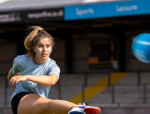 student kicking ball